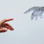 Mão humana e mão robótica se aproximando, representando a evolução de data-driven para AI-first