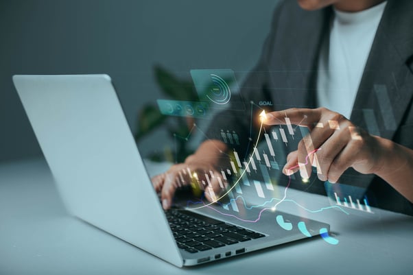 Mãos em notebook com gráfico de crescimento projetado, representando growth hacking
