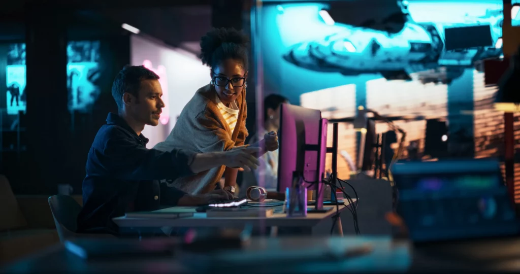 Equipe de tecnologia trabalhando em computadores em escritório moderno
